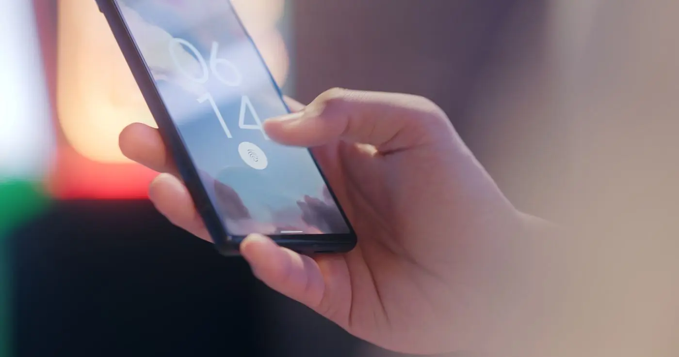 Hand entsperrt ein Smartphone per Fingerabdruck — ID Austria und BundID machen das Handy zum Ausweis