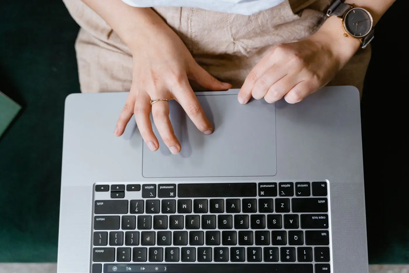 Hände am Laptop-Trackpad beim Bestätigen eines Kaufs — je nach Zahlungsmethode passiert danach Verschiedenes